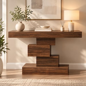 May include: A dark brown wooden console table featuring a unique geometric base composed of stacked rectangular blocks. The table has a long, flat top surface and a sturdy, multi-tiered support structure that creates a distinct, layered appearance.