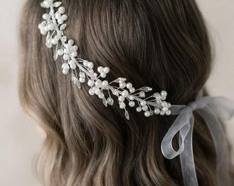 May include: A hair vine accessory featuring a flexible silver-toned wire base adorned with small white faux pearls and clear crystal accents. The piece is secured with a sheer grey ribbon tied into a bow at the back of the head.