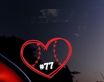 May include: A red heart-shaped baseball sticker with white stitching and the number "77" inside. The sticker is on the rear window of a blue car. The design resembles a baseball.