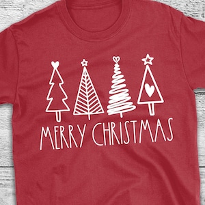 May include: Red t-shirt with a white graphic of four Christmas trees and the words "MERRY CHRISTMAS". The shirt has a crew neck and short sleeves. The text "Iron On ONLY! Shirt not included" is printed at the bottom.