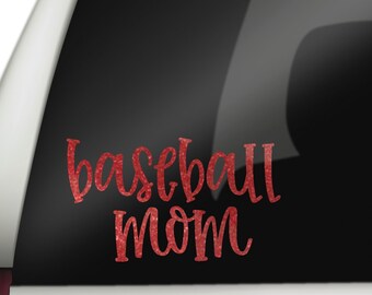May include: Red glitter vinyl car decal with the text "baseball mom" in a cursive font.