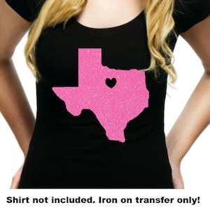 May include: Pink glitter iron-on transfer of the state of Texas with a small black heart in the center.  Shirt not included. Iron on transfer only.