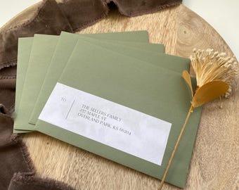 May include: A stack of green envelopes with a white label addressed to "THE SELLERS FAMILY, 237 MAPLE ST, OVERLAND PARK, KS 66204".