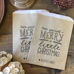 May include: Two brown paper gift bags with the text "have yourself a merry little christmas" and "The Beyers Family" printed on them.
