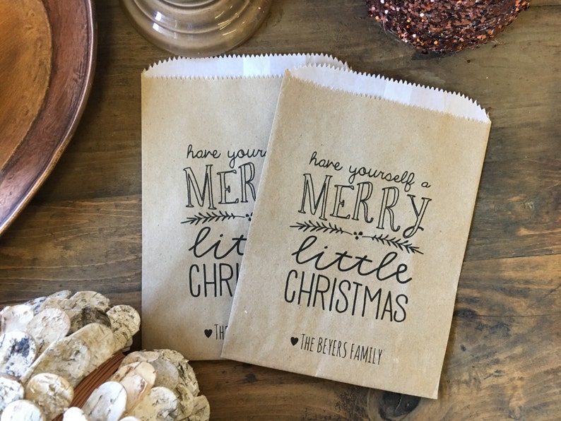 May include: Two brown paper gift bags with the text "have yourself a merry little christmas" and "The Beyers Family" printed on them.