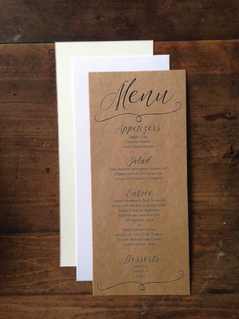 May include: A rustic menu card with the word "Menu" in elegant script at the top. The menu is printed on a brown card with a white and cream-colored card behind it. The menu lists appetizers, salad, entree, and desserts.