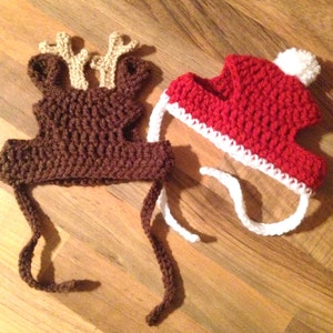 May include: Two crocheted pet hats, one brown with reindeer antlers and one red with a white pom-pom.