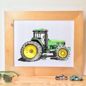 May include: A watercolor painting of a green tractor with yellow wheels. The tractor is framed in a light wood frame.