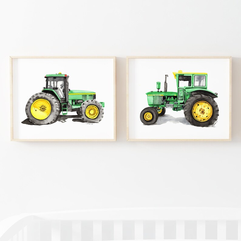 May include: Two watercolor paintings of green tractors on a white background. The tractors are both facing the left side of the image. The tractor on the left is a larger model with a yellow wheel. The tractor on the right is a smaller model with a yellow wheel and a yellow stripe on the top of the cab.