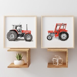 May include: Two framed watercolour paintings of red tractors on a white background. The tractors are both facing the right side of the image. The tractors are both on a white background. The paintings are hanging on a wall with two wooden shelves underneath.