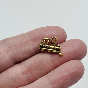 May include: Gold-toned metal train charm with a loop for attaching to a necklace or bracelet.