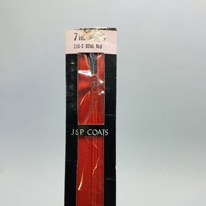 May include: A 7-inch red zipper in a black and white package. The package says "J&P COATS" and "136-C DEVIL RED".