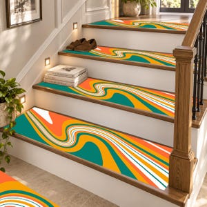 May include: A set of stair treads featuring a wavy, abstract pattern in vibrant shades of teal, orange, yellow, and white. The rectangular treads are applied to each step of a wooden staircase, creating a continuous, flowing visual effect.