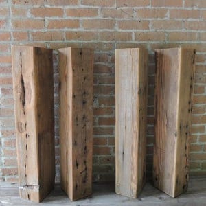 May include: Four reclaimed wood beams, each with a rustic, weathered appearance. The beams are approximately 10 inches wide and 6 feet long. They are perfect for adding a touch of rustic charm to any home decor project.