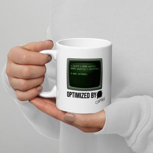 May include: A white ceramic mug featuring a graphic of a vintage computer monitor displaying green code that reads SELECT * FROM reality WHERE deadline > yesterday; 0 ROWS RETURNED. Below the monitor is the text OPTIMIZED BY COFFEE.