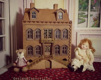Könnte beinhalten: Ein Miniatur-Puppenhaus aus Holz mit braunem Äußeren und goldenen Akzenten. Das Puppenhaus hat mehrere Fenster und eine Veranda mit Treppen. Ein Teddybär und eine Puppe sitzen vor dem Puppenhaus.