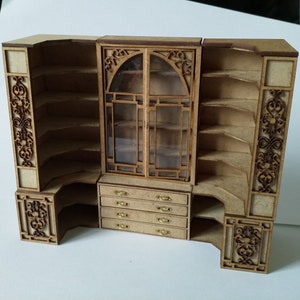 May include: A wooden corner cabinet with glass doors and intricate carvings. The cabinet has multiple shelves and drawers.