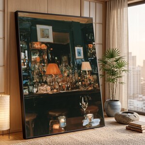 May include: A large framed rectangular wall art piece depicting a dimly lit bar interior with dark green walls, a wooden counter, numerous glass bottles, two lamps with warm orange and white shades, and a wine glass on a foreground table.