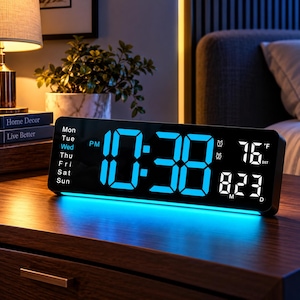 May include: A rectangular digital alarm clock with a black frame and a bright blue LED display. The screen shows the time 10:38, the day of the week as Wednesday, the temperature as 76 degrees Fahrenheit, and the date as 8/23.