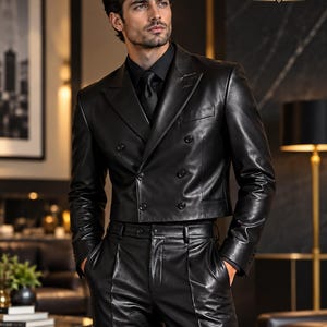 Könnte beinhalten: Ein schwarzer, zweireihiger, kurzer Lederblazer und eine passende schwarze Lederhose. Der Blazer hat ein breites Revers, vier Knöpfe und lange Ärmel. Der Text ProLeathers04 mit einem Kronensymbol ist in der oberen rechten Ecke zu sehen.