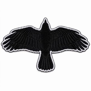 May include: An embroidered patch in the shape of a bird with wings spread wide. The bird is primarily black with a distinct white border outlining the entire silhouette, including the feathers on the wings and the tail, creating a high-contrast design.