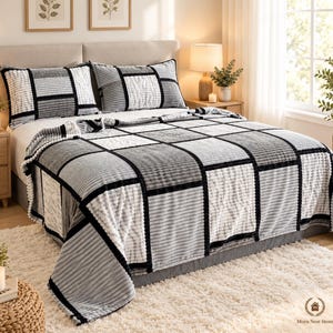 May include: A bed set featuring a quilt and two matching pillow shams with a patchwork design of alternating white, light gray, and dark gray rectangular blocks. The fabric has a textured, ribbed surface with black piping borders.