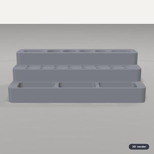 May include: A gray, three-tiered desk organizer featuring a top level with various circular and oval slots, a middle level with multiple small circular holes, and a bottom level with three rectangular compartments for storage and organization.