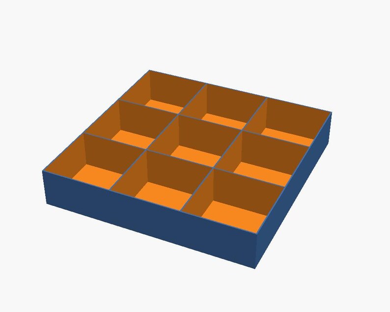 May include: A square storage tray with a dark blue exterior and nine individual compartments. The interior walls and base of each section are a bright orange colour, creating a high-contrast grid design for organising small items.
