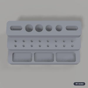 May include: A light gray tiered desk organizer featuring a top level with two elongated slots and four circular holes, a middle level with fourteen small circular holes, and a bottom level with three rectangular compartments.