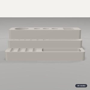Puede incluir: Un organizador de escritorio escalonado de color gris claro con m&uacute;ltiples orificios circulares de varios tama&ntilde;os en los niveles superior y medio, adem&aacute;s de una ranura rectangular larga y un compartimento en el nivel inferior.
