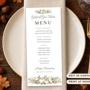 May include: A vertical white menu card featuring botanical illustrations of pumpkins and wheat. The text reads Gather & Give Thanks, MENU, courses, Happy Thanksgiving, and THE HAYES FAMILY. It sits on a beige napkin and white plate.