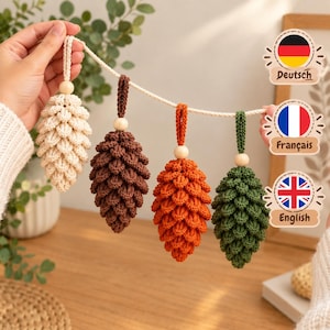 May include: A garland featuring four crocheted pinecone ornaments in cream, brown, orange, and green. Each pinecone is suspended from a cream-colored rope by a small wooden bead and a matching crocheted loop, creating a textured, seasonal display.