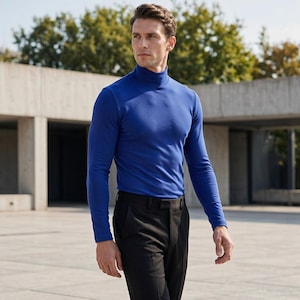 May include: A long-sleeved, royal blue polo neck jumper paired with black trousers. The jumper features a fitted silhouette with a high, folded collar and long sleeves, while the trousers are tailored with a clean, flat-front design.