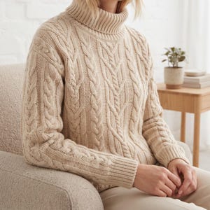 Peut inclure: Un pull en tricot torsadé beige doté d'un col roulé haut et de manches longues avec des poignets côtelés. Le vêtement est construit avec un motif tressé vertical sur le devant et les manches, offrant un aspect texturé sur tout le tricot.