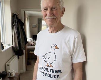 May include: A white short-sleeved t-shirt featuring a graphic of a white goose wearing glasses, with the text "I SPOIL THEM. IT'S POLICY." printed in black capital letters below the illustration on the front of the garment.