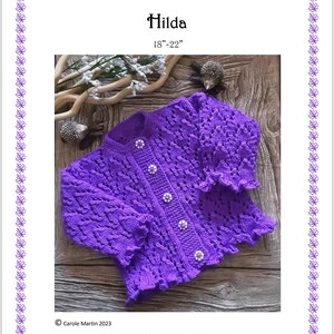 May include: A vibrant purple knitted cardigan featuring a textured leaf pattern, long sleeves with ruffled cuffs, and five round decorative buttons. The text reads Prickles & Whiskers Baby Designs Hilda 18"-22" and Carole Martin 2023. This pattern remains the property of the designer and should not be copied, shared or re-sold.