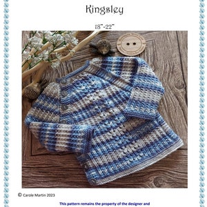 Könnte beinhalten: Eine gestrickte Babyjacke in Blau und Grau mit Streifen und Knopfverschluss. Die Jacke liegt auf einer Holzoberfläche. Der Text "Prickles & Whiskers Baby Designs Kingsley 18"-22" Handgefertigt mit Liebe" ist auf dem Bild zu sehen.