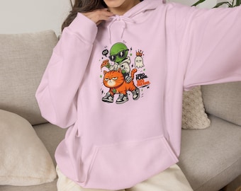 May include: A light pink hooded sweatshirt featuring a graphic print of a green alien wearing sunglasses and a hoodie, riding an orange tabby cat. The cat wears sneakers and a small green pendant. Text reads: ZERO PLANS. BIG DREAMS.