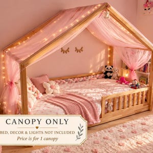 May include: A sheer pink fabric canopy draped over a wooden house-shaped bed frame. The canopy features a rectangular sign that reads CANOPY ONLY, BED, DECOR & LIGHTS NOT INCLUDED, Price is for 1 canopy. The frame is light-colored wood.