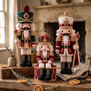 Peut inclure: Trois figurines casse-noisette en crochet avec un travail de fil complexe. Deux personnages debout portent des chapeaux hauts et tiennent des sceptres à gemmes rouges, tandis qu'un plus petit est assis sur un tambour rouge, avec barbes et moustaches.