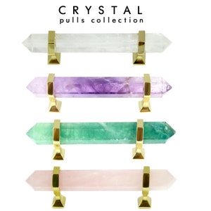 Op de afbeelding: Vier kristallen kastgrepen met gouden metalen accenten. De kristallen zijn helder, paars, groen en roze.