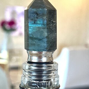 gemstone wine stopper is made with flash labradorite and stainless steel. the stone stopper is a bar decor idea