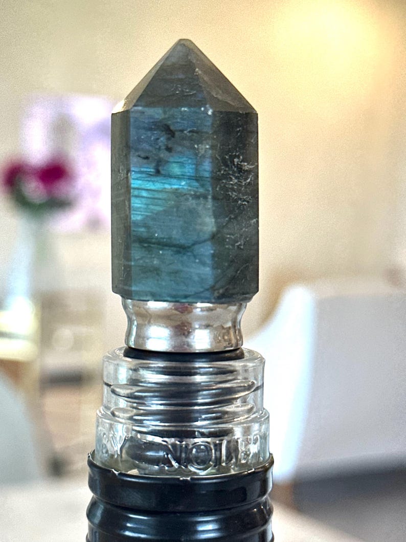 gemstone wine stopper is made with flash labradorite and stainless steel. the stone stopper is a bar decor idea