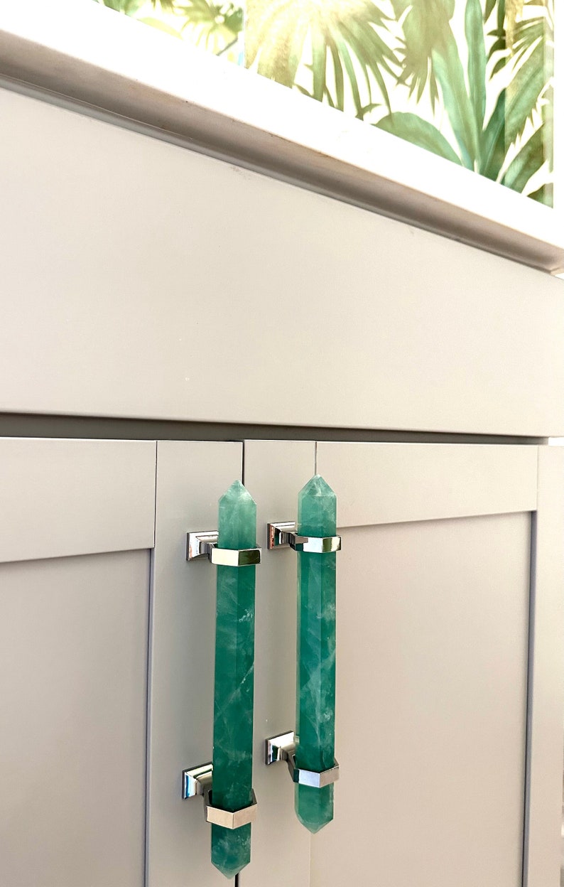 emerald green handles with chrome hardware on a bathroom vanity in a luxurious bathroom with tropical wallpaper from Versace luxury interior design ideas interior decorator green home decor high end hardware
