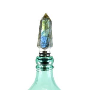 the wine stopper is on a fancy bottle of expensive liquor from the bar cabinet