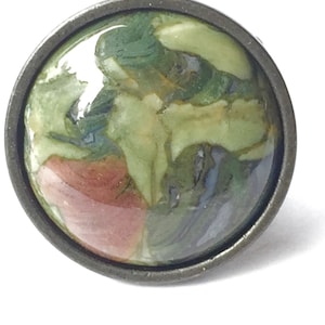 May include: A round, green, brown, and white patterned cabochon set in a silver-toned metal ring.