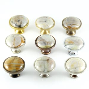 Peut inclure: Assortiment de dix boutons ronds pour armoire avec un motif marbré dans des tons de blanc, brun et or. Les boutons ont différentes finitions, notamment en laiton, en bronze et en chrome.