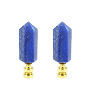 May include: Two blue lapis lazuli lamp finials with gold bases. The finials are shaped like a point and have a textured surface.