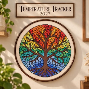 May include: A circular cross-stitch embroidery featuring a tree with a brown trunk and branches, filled with a mosaic of rainbow-colored squares. Above the embroidery, a rectangular sign displays the text Temperature Tracker 2027.