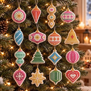 May include: A collection of sixteen cross-stitch Christmas ornaments in various shapes including spheres, stars, trees, and bells. Each ornament features intricate geometric patterns in vibrant colors like pink, blue, green, orange, and yellow, all suspended by gold-toned loops.